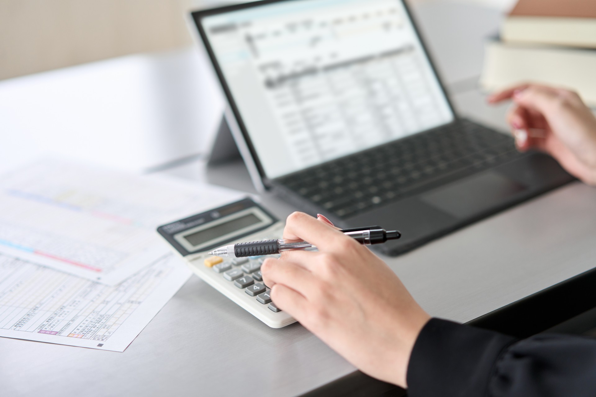 Asian woman entering journal entries in accounting software